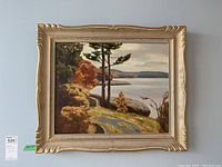 Full frontal view of the framed painting on wall with lot tag visible