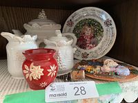 Photo shows the full Christmas lot displayed on a lace doily with two collectors plates, a red candle holder, ceramic vase, and the Bella Casa teapot set.