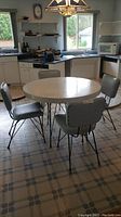 Full view of round Arborite table with four chairs in kitchen setting