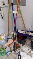 Full view of assorted floor mops, mop heads, buckets, mop pads in various packaging and instructions on floor.