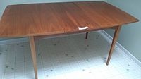 Full view of teak dining table with leaf inserted
