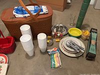 Wide view of picnic basket with plates, cups, cutlery, napkins, and various utensils