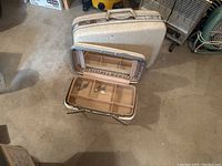 Large and small Samsonite luggage pieces displayed together; smaller with compartment tray partly open.