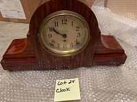 Front view of brown wooden Seth Thomas mantel clock with brass bezel and cream dial showing Arabic numerals.