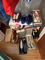 Wide view of shoe collection on shelves and floor showing slippers, dress shoes, flats and sneakers.