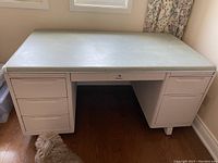 Front view of a heavy metal desk showing top surface and drawers