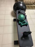 Top view of weight bench with various fitness equipment on top and behind it.