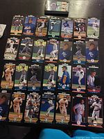 Photo showing 24 MLB baseball cards laid out on a table, featuring players from teams like Mets, Royals, Athletics, Blue Jays, Cubs and more.