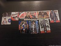 Photo showing 13 NBA basketball trading cards including Devin Booker and various moment and highlight cards in near mint condition.