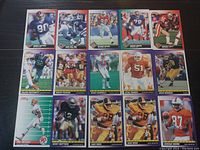 Photo showing 13 NFL Score 1991 football trading cards laid out in three rows. Cards depict various players in action poses, wearing team football uniforms.