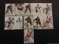 Nine NHL hockey cards laid out on a dark surface, players shown in action, cards in near mint condition