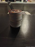 Stack of approximately 50 round NHL hockey cards showing edges with various colors, stacked on a dark table.