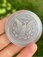 Reverse of 1891 American Silver Dollar coin showing eagle with arrows and olive branch, In God We Trust inscription