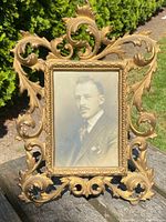 Front view of the antique French solid bronze picture frame with ornate acanthus leaf decoration and a vintage portrait photograph inserted.