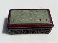 Top view of the closed wooden box showing the rectangular carved jade panel inset into the lid.
