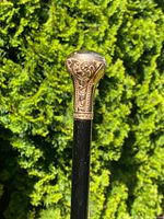 Close-up of gold-topped handle with scroll engraving