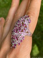 Front angle showing marquise and round ruby stones in silver openwork pattern on the ring.