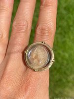 Top view of ring on finger showing carved glass cameo and silver bezel