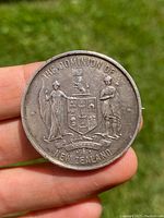 Front side of the silver medal showing the Dominion of New Zealand coat of arms with two figures and a banner.