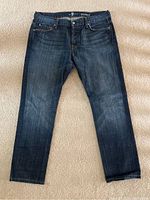 Front view of the men's blue denim jeans showing color, size, and general wear.