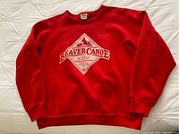 Front view of vintage red crewneck sweatshirt with Beaver Canoe diamond-shaped graphic in white and ribbed cuffs, collar and waistband.