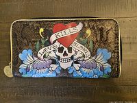 Front view showing skull, heart, and flower design with 'Love Kills Slowly' banner.