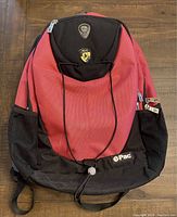 Full view of pink and black Heys backpack with front elastic string and mesh side pockets.