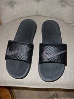 Top view of the black Nike slides showing textured strap with Nike swoosh logo and molded footbed.