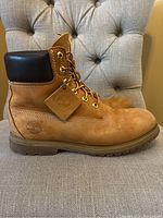 Side profile of left Timberland 6-inch boot showing Nubuck leather, padded collar, and metal eyelets.