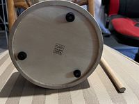 Underside of wooden drum showing Plan Toys logo and rubber feet