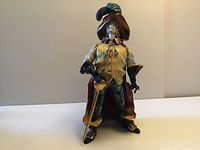 Front view of the cavalier figure standing upright on a plain white surface with neutral background, showcasing colorful and detailed attire.