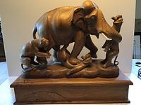 Front view of the full sculpture showing elephant and two lions on wooden base