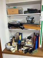 Shelf with various office items including boxes, folders, staplers, and Panasonic CD player
