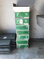Stack of 7 green and white Windsor Ceramics branded boxes containing ceramic tiles.