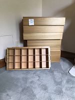 Six wooden crates with internal dividers for glassware or ornament storage, with lids and handles visible.