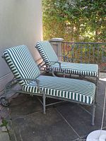 Two chaise lounges side by side with cushions attached