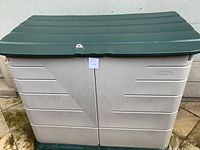 Front view of closed storage bin showing hinged lid and overall condition