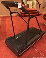 Full side view of the treadmill showing the handrails and running belt.