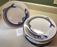 Multiple plates stacked with two displayed on stands showing overall set