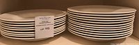 Two stacks of white wide‐rim pasta bowls with lot label