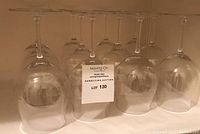 Twelve identical clear red wine glasses arranged upside-down and right-side-up