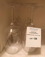 Eight vintage Riedel white wine glasses arranged upright showing their bowls and stems, tagged as Lot 129