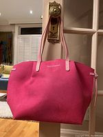 Front view of the hot pink Juicy Couture tote bag showcasing the shape, handles, and logo on the front.