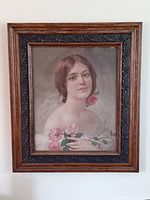 Full view of oak framed lithograph portrait depicting a woman holding pink roses.