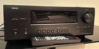 Front view of Denon AVR-1912 with remote laid on gloss surface