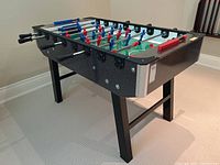 Full view of table showing black laminate body, legs and rod handles