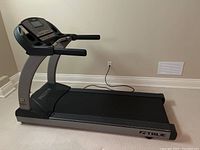 Side profile view of treadmill showing running deck and frame