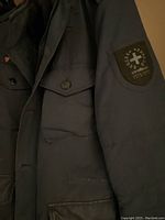 Close-up of Strellson navy coat left sleeve with brand patch