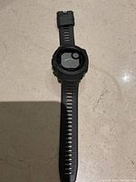 Full top-down view of the Garmin Instinct watch showing the black silicone strap and round digital face with bezel.