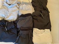 Overview of eight Lululemon items laid out, showing various tops, hoodies and pants
